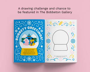 An open illustrated magazine spread on a pink background. The left page is bright blue with the words 'BOBBETY GREETINGS!' and a colorful winter scene inside a snow globe illustration.