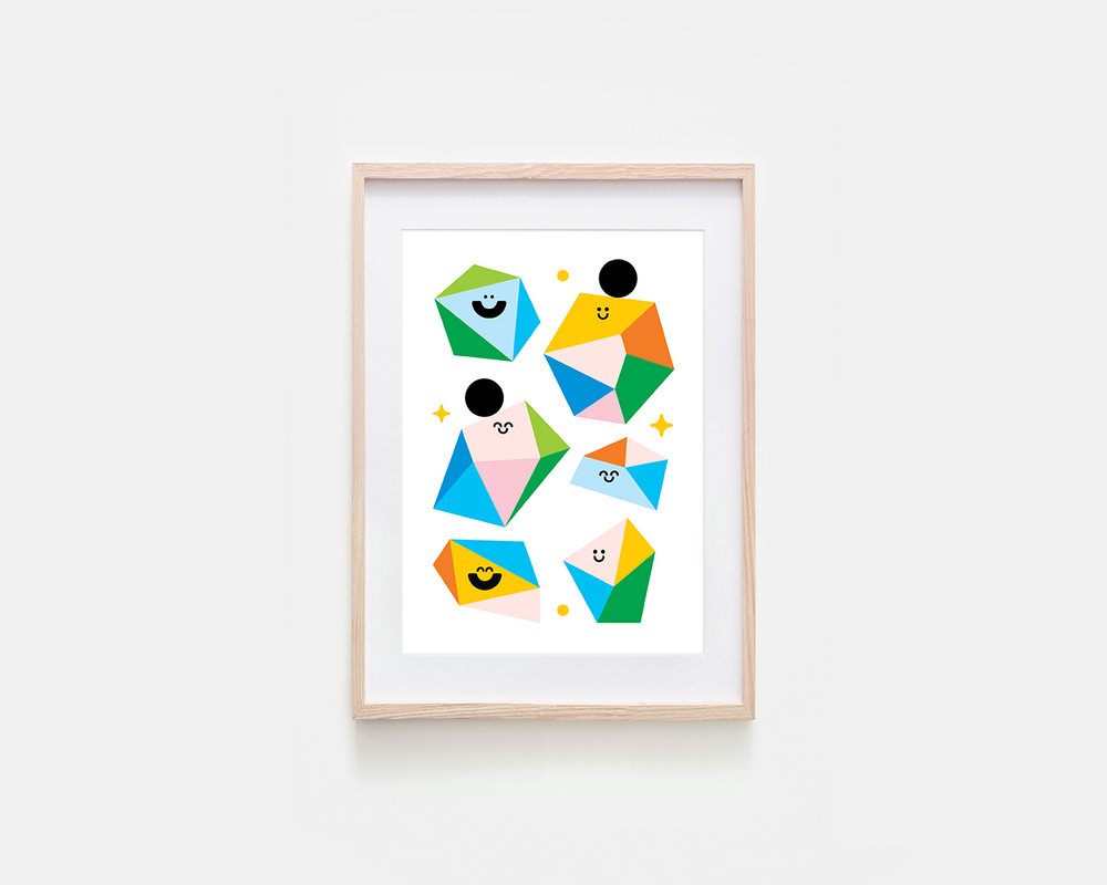 A framed art print featuring colorful geometric figures with minimalist faces, displayed on a light gray wall. The print has a white background with abstract shapes in green, blue, yellow, orange, pink, and black, enclosed in a light natural wood frame.