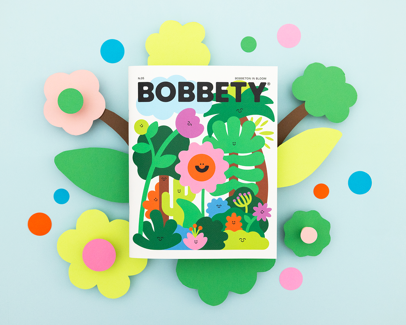 Magazine titled 'Bobbety' with colorful illustrations on a light blue background with flowers and leaves.